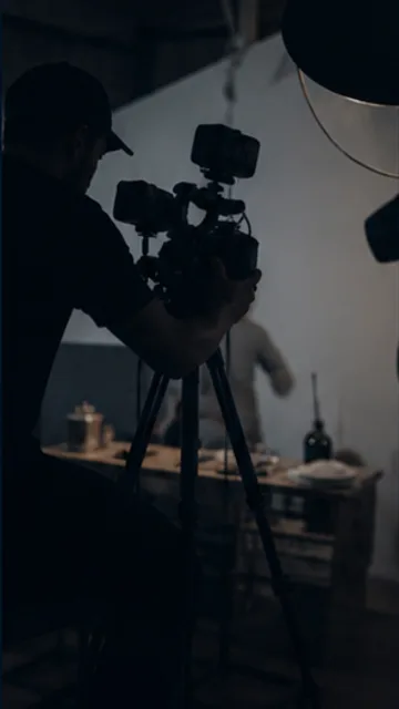 A camera operator filming a speaker